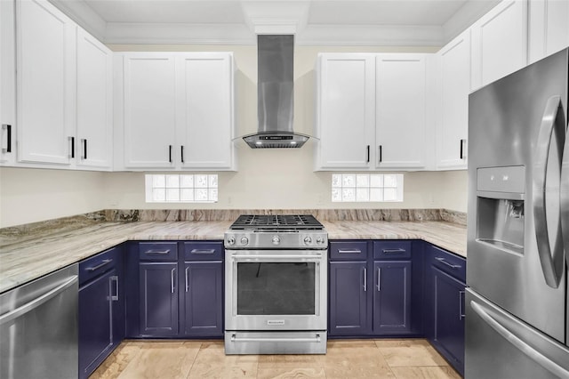 kitchen featuring a healthy amount of sunlight, blue cabinets, appliances with stainless steel finishes, and wall chimney range hood