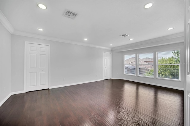 spare room with dark hardwood / wood-style flooring and crown molding