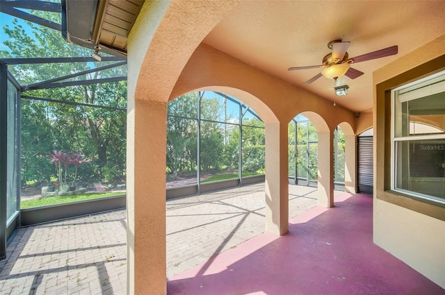 unfurnished sunroom featuring ceiling fan