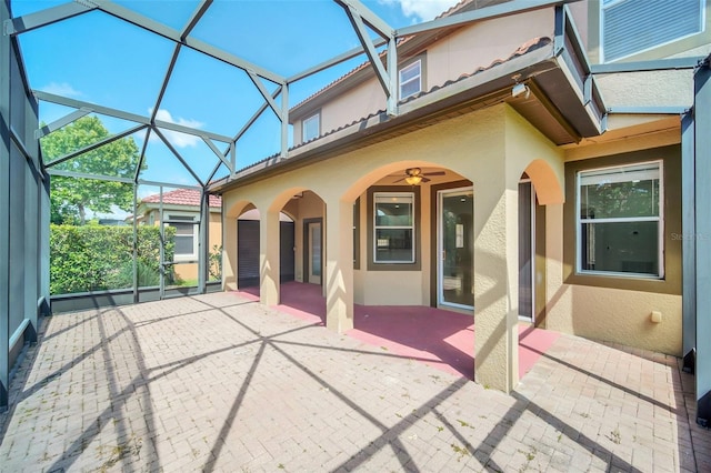 unfurnished sunroom featuring ceiling fan