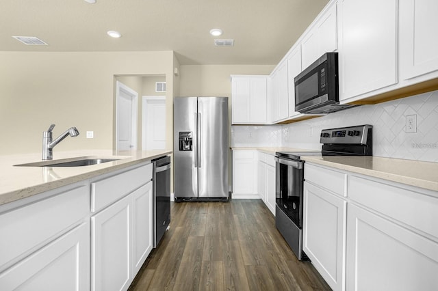 kitchen featuring dark hardwood / wood-style floors, sink, white cabinets, stainless steel appliances, and light stone countertops