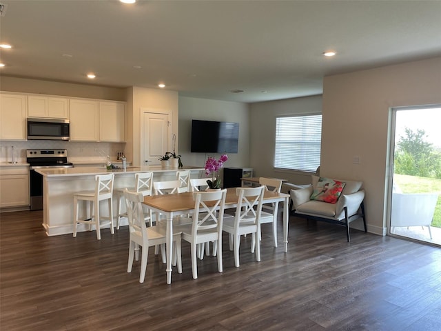 dining space with dark hardwood / wood-style floors and a healthy amount of sunlight