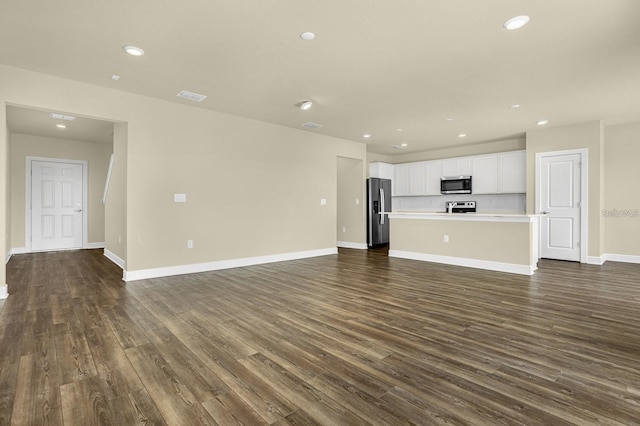 unfurnished living room featuring dark wood-type flooring