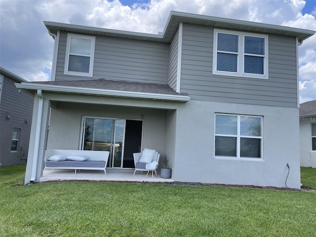 back of property featuring a patio area and a lawn