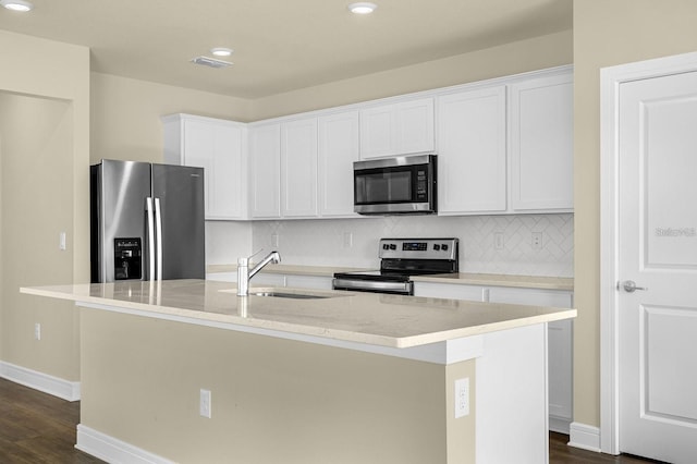 kitchen featuring stainless steel appliances, sink, a kitchen island with sink, and white cabinets