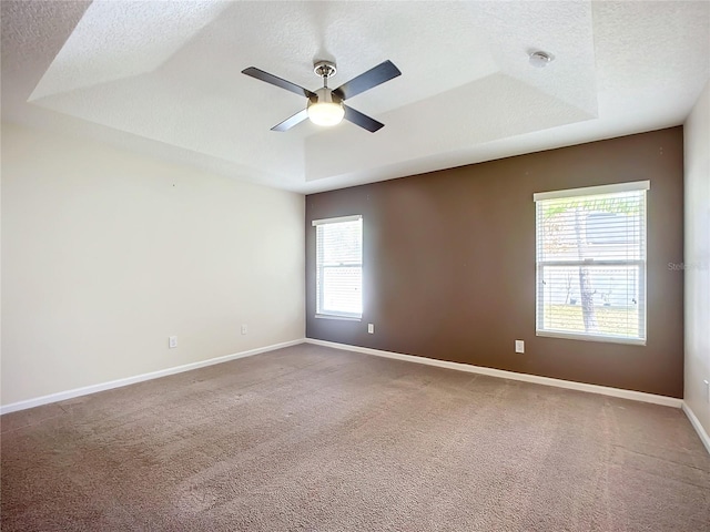 spare room with carpet flooring, ceiling fan, and a healthy amount of sunlight