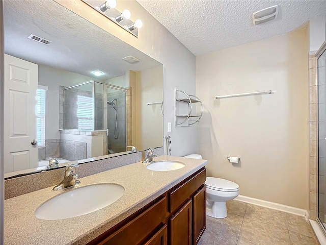 bathroom featuring tile patterned flooring, an enclosed shower, a textured ceiling, toilet, and vanity