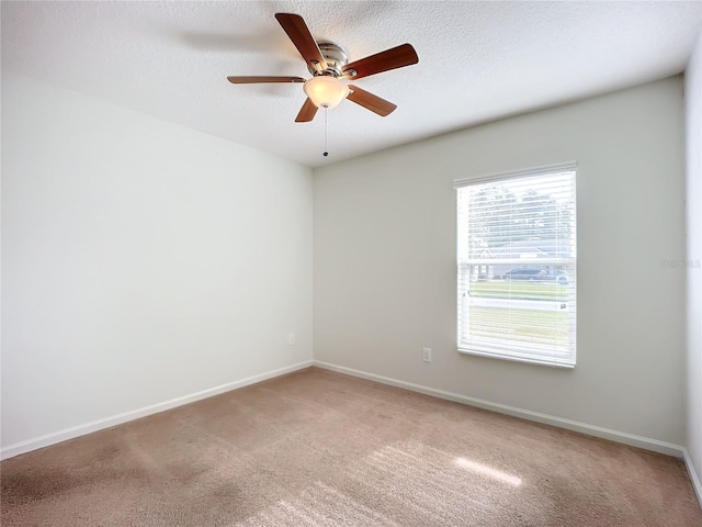 empty room featuring ceiling fan, carpet floors, and a textured ceiling