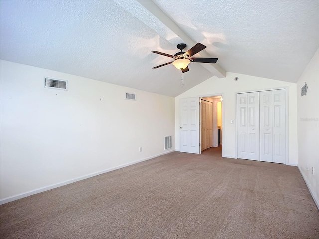 unfurnished bedroom with carpet flooring, ceiling fan, and lofted ceiling with beams