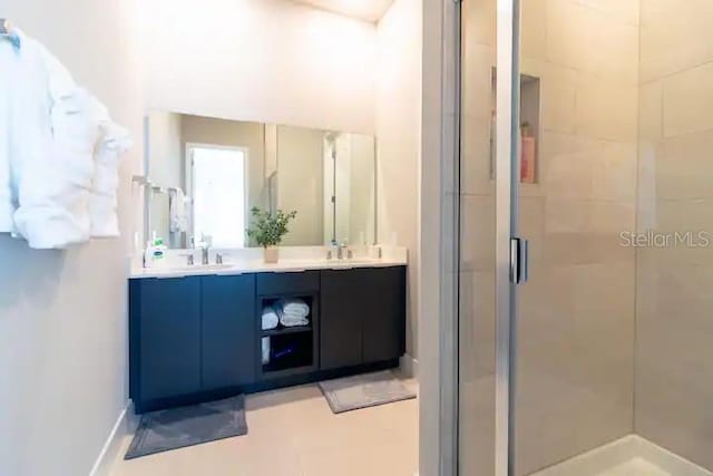 bathroom with a shower with shower door and dual vanity