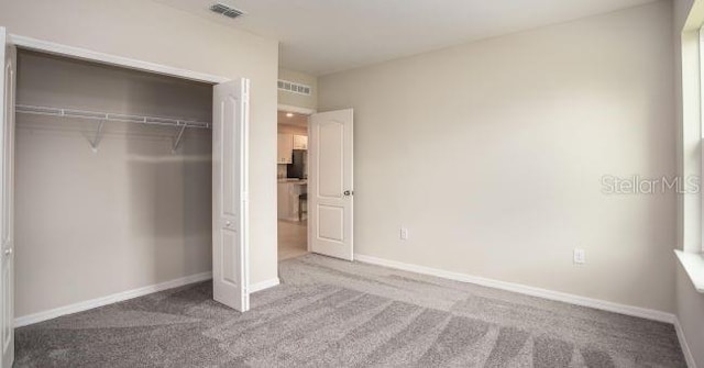 unfurnished bedroom featuring a closet and carpet flooring