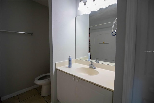 bathroom featuring tile floors, vanity with extensive cabinet space, and toilet