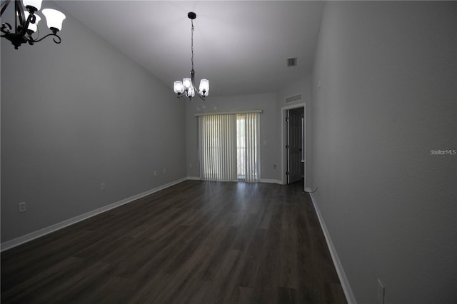 unfurnished room featuring dark hardwood / wood-style flooring and an inviting chandelier