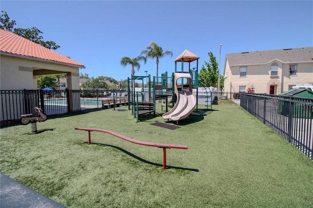 view of playground with a community pool and a yard