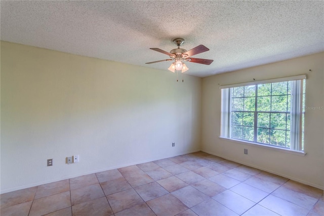 empty room featuring light tile patterned flooring, a textured ceiling, and ceiling fan