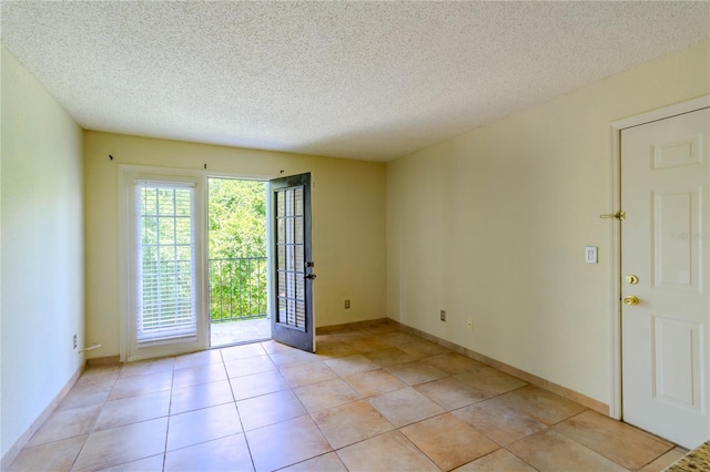 doorway to outside with light tile patterned floors and a textured ceiling