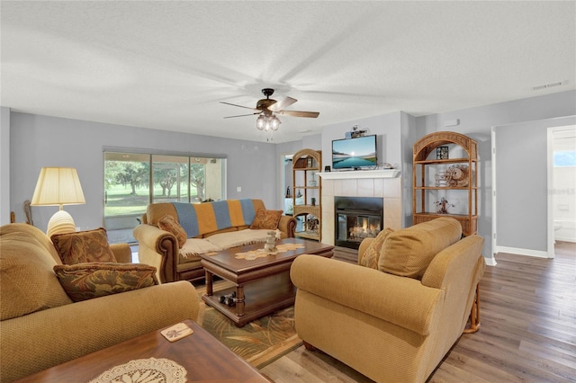 living room with wood-type flooring, a fireplace, and plenty of natural light