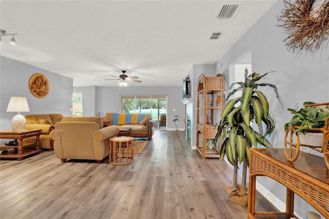 living room with wood-type flooring, ceiling fan, and rail lighting