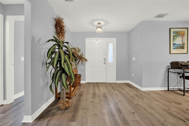 entryway featuring hardwood / wood-style floors and a textured ceiling