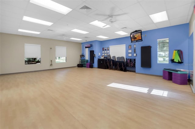 interior space with hardwood / wood-style floors, a paneled ceiling, and a wealth of natural light