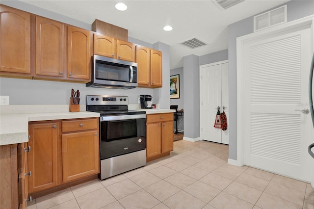 kitchen with light tile patterned flooring and appliances with stainless steel finishes