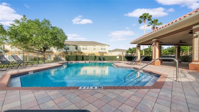 view of swimming pool featuring ceiling fan and a patio area