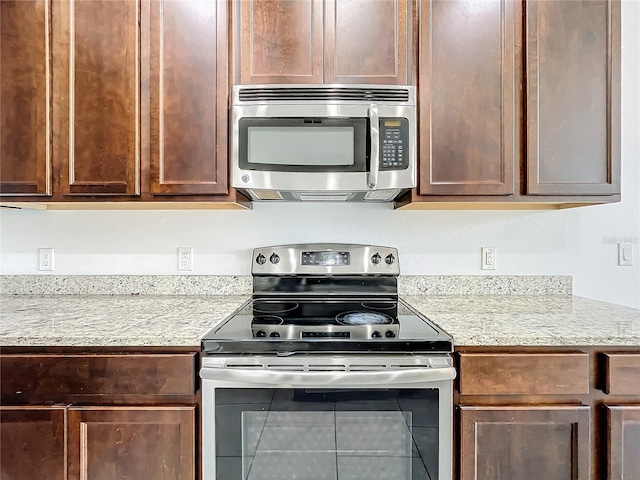 kitchen with stainless steel appliances and light stone counters