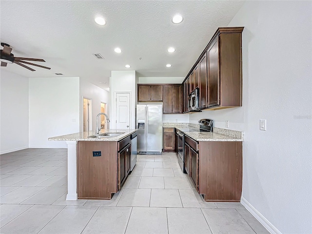 kitchen featuring appliances with stainless steel finishes, a center island with sink, light tile patterned flooring, and sink