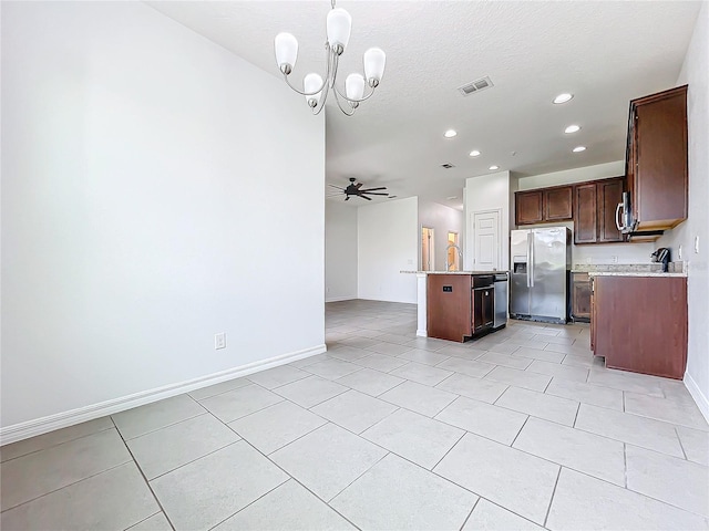 kitchen featuring pendant lighting, a kitchen island, ceiling fan with notable chandelier, appliances with stainless steel finishes, and light tile patterned flooring