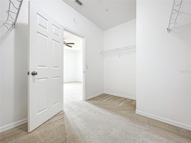 walk in closet with carpet flooring and ceiling fan