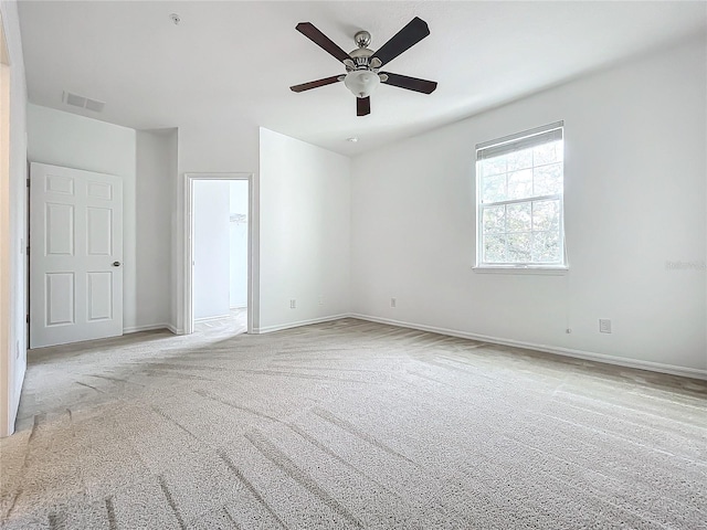 unfurnished bedroom featuring ceiling fan, light carpet, and a walk in closet