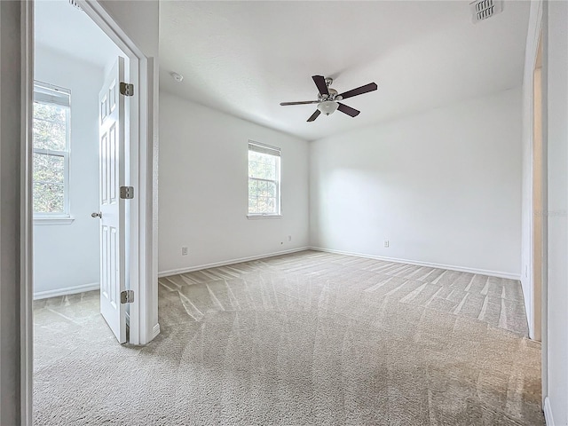 spare room with plenty of natural light and light colored carpet