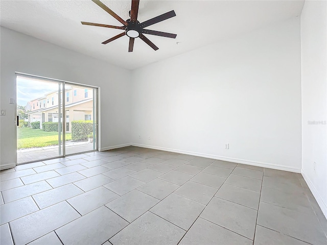 tiled spare room featuring ceiling fan