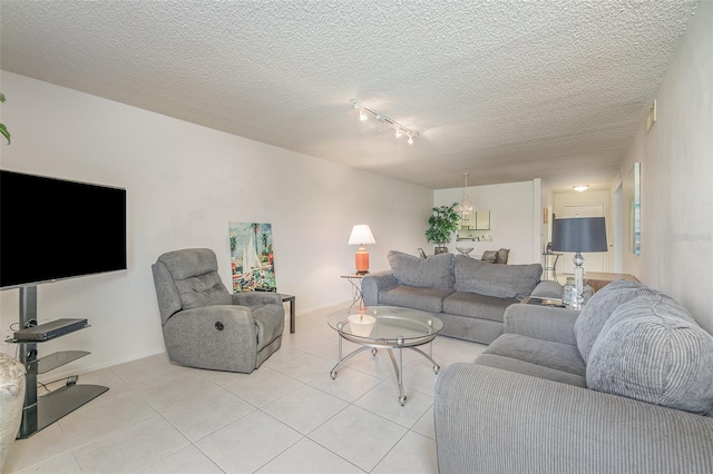 tiled living room featuring track lighting and a textured ceiling