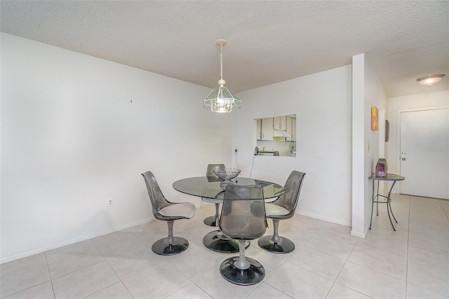 dining area featuring light tile floors and a textured ceiling