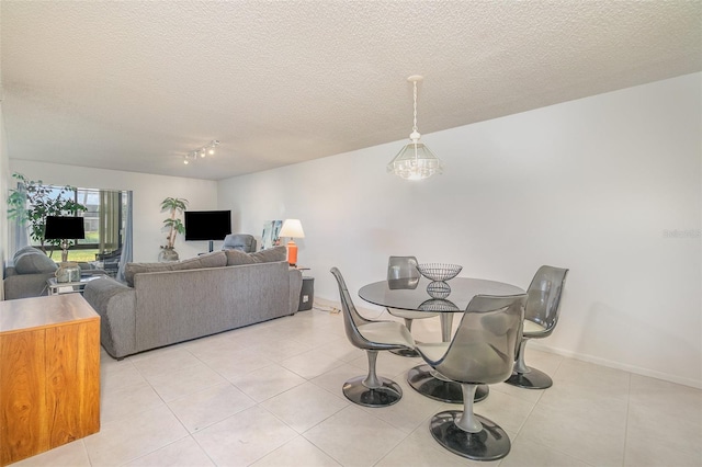 dining space featuring light tile flooring and a textured ceiling