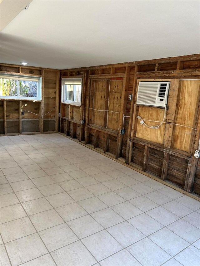 empty room featuring wooden walls and a wall mounted air conditioner