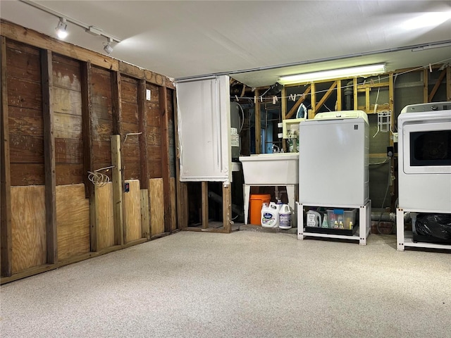 basement with washer and clothes dryer and sink