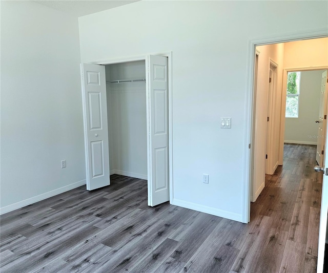 unfurnished bedroom with a closet and dark hardwood / wood-style flooring