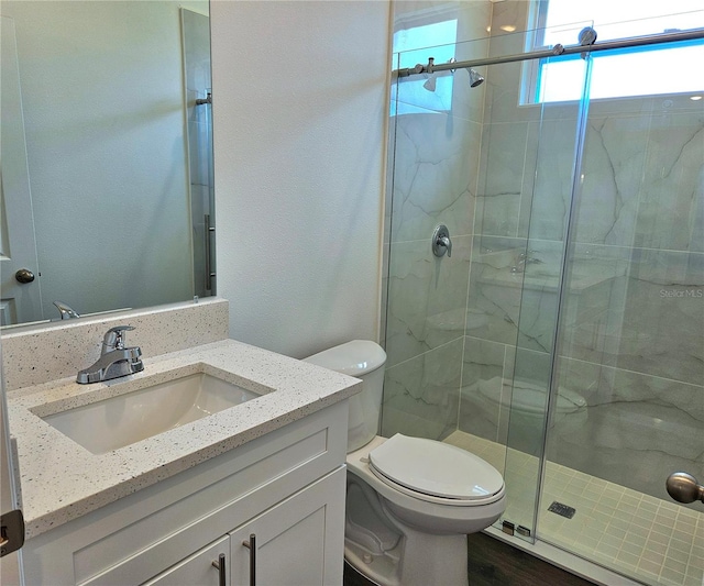 bathroom featuring walk in shower, toilet, and oversized vanity