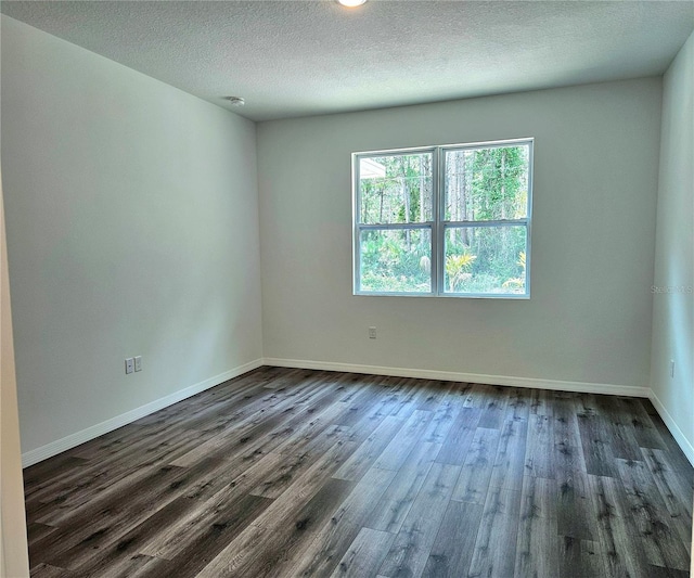 empty room with a textured ceiling and dark wood-type flooring