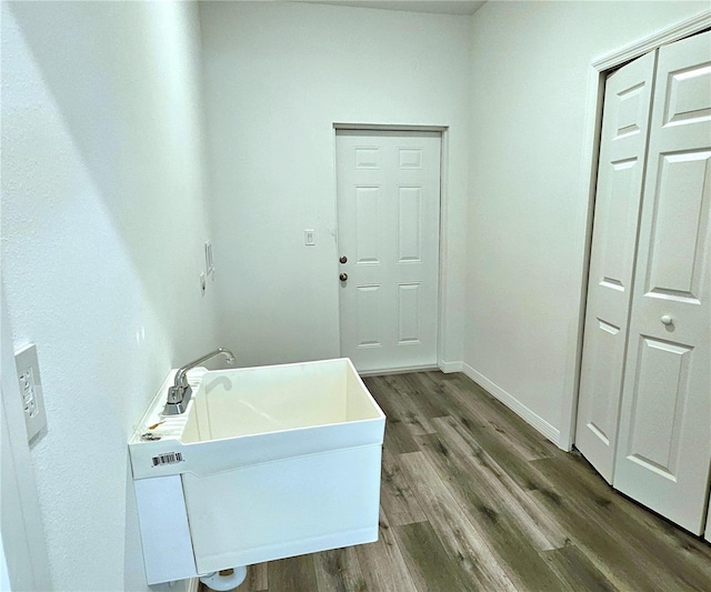 laundry room with hardwood / wood-style flooring and sink