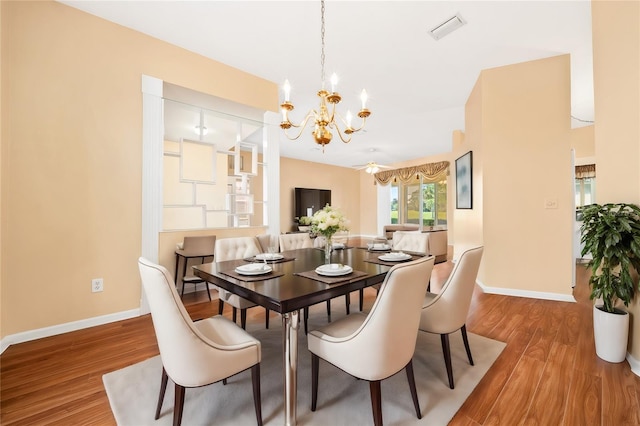 dining room with wood-type flooring and an inviting chandelier