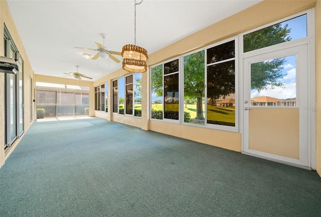 unfurnished sunroom featuring ceiling fan