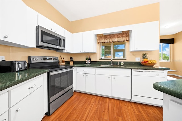 kitchen with a healthy amount of sunlight, appliances with stainless steel finishes, white cabinetry, and sink