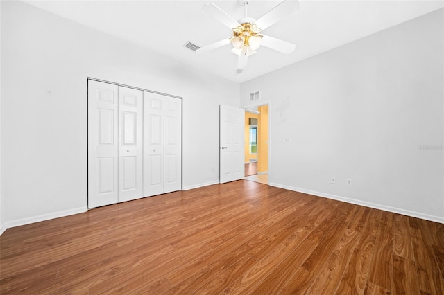 unfurnished bedroom featuring a closet, wood-type flooring, and ceiling fan