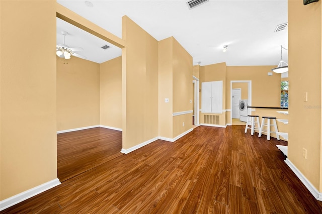 spare room featuring lofted ceiling, ceiling fan, washer / clothes dryer, and hardwood / wood-style floors