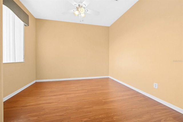 empty room with hardwood / wood-style flooring, lofted ceiling, and ceiling fan