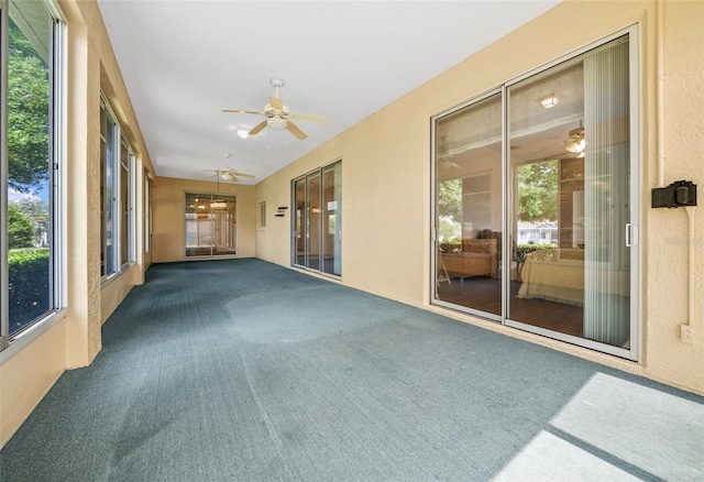 unfurnished sunroom with ceiling fan