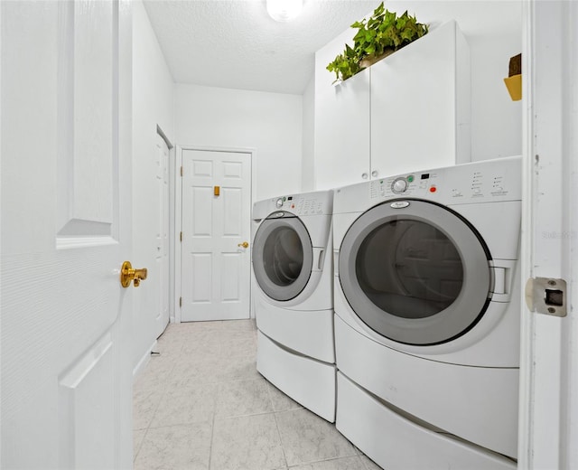 laundry room with light tile floors and washing machine and clothes dryer